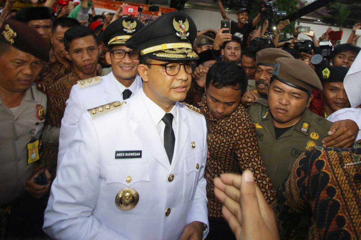 Gubernur DKI Jakarta Anies Baswedan (depan) bersama Wakil Gubernur DKI Jakarta Sandiaga Uno (belakang) berjalan untuk memasuki ruangan saat tiba di Balai Kota, Jakarta, Senin (16/10/2017). Anies Baswedan dan Sandiaga Uno resmi menjadi Gubernur dan Wakil Gubernur DKI Jakarta periode 2017-2022 menggantikan pasangan Basuki Tjahaja Purnama dan Djarot Saiful Hidayat.