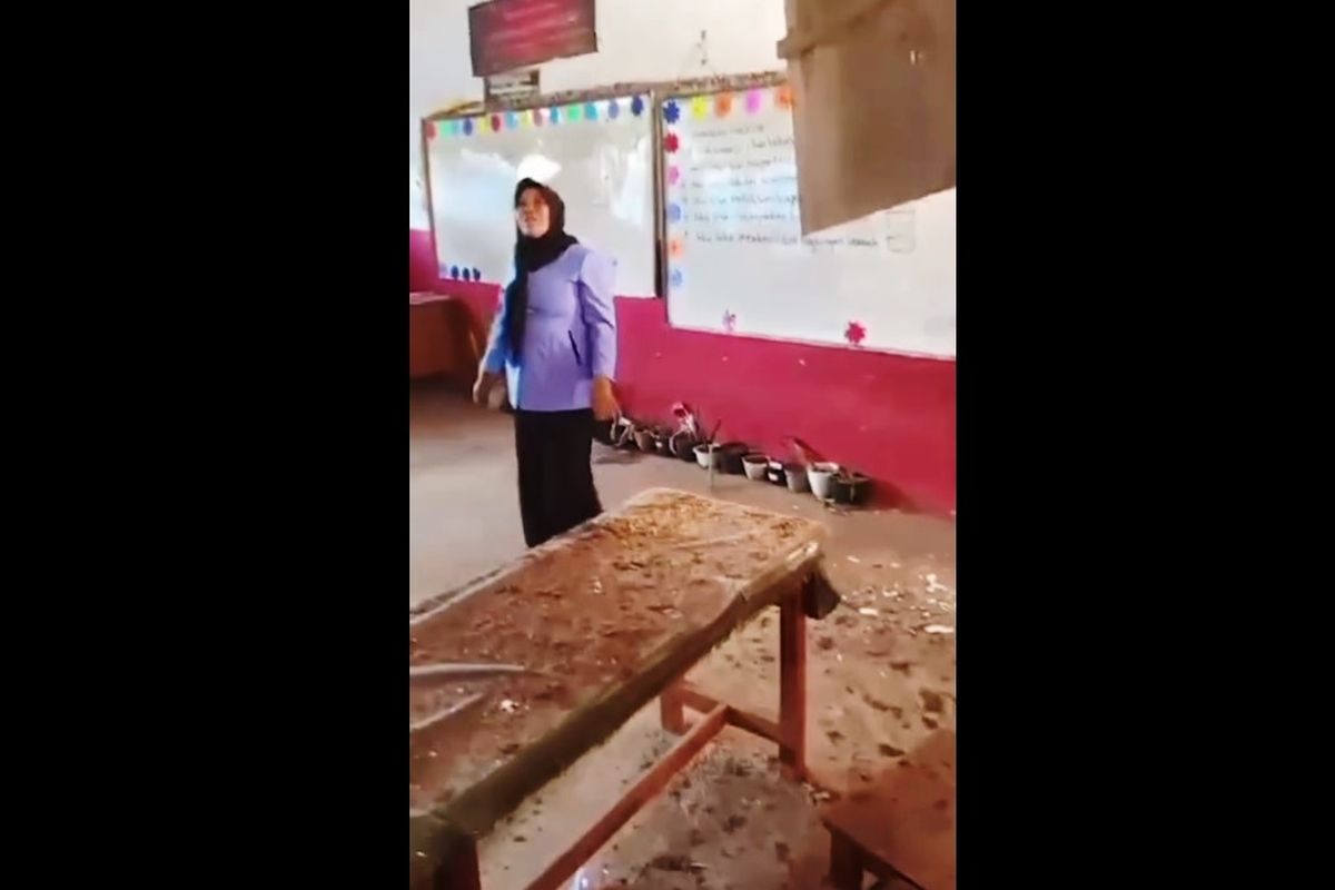 Seorang guru di Kecamatan Cibeber, Kabupaten Cianjur, Jawa Barat memperlihatkan kondisi plafon kelasnya yang ambruk akibat gempa, Kamis (21/11/2024).