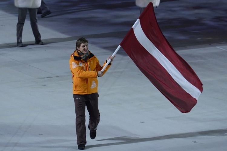 Pemain hockey Sandis Ozolins membawa bendera Latvia pada pembukaan Olimpiade Musim Dingin Sochi pada 7 Februari 2014. (AFP/Jonathan Nackstrand)
