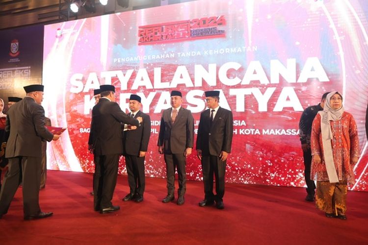 Wali Kota (Walkot) Makassar Mohammad Ramdhan Pomanto menyematkan Tanda Kehormatan Satyalancana Karya Satya kepada 12 pegawai negeri sipil (PNS) di Kota Makassar di sela-sela acara momentum Refleksi Akhir Tahun 2024 Kota Makassar di Hotel Four Points by Sheraton, Jumat (27/12/2024).
