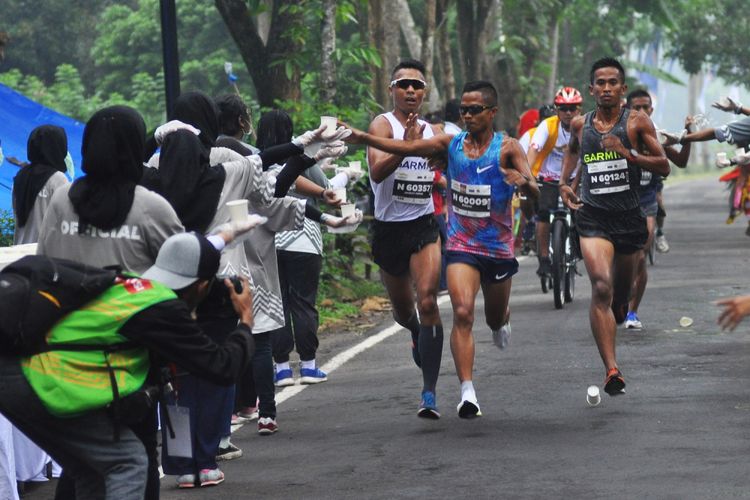 Sejumlah pelari mengambil gelas berisi menuman pada Bank Jateng Borobudur Marathon (BJBM) 2017 di Taman Wisata Candi (TWC) Borobduur, Magelang, Jateng, Minggu (19/11). Sebanyak 8.754 peserta dari dalam dan luar negeri mengikuti BJBM yang meombakan tiga kategori Full Marathon (42 km), Half Marathon (21 km) dan 10 K (10 km) dengan total hadiah sebesar  Rp 2,3 miliar. ANTARA FOTO/Anis Efizudin/ama/17