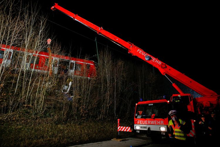 Anggota tim tanggap darurat melakukan evakuasi dua kereta komuter S-bahn yang bertabrakan dan menyebabkan satu orang tewas serta 14 korban luka-luka di distrik Schaeftlarn, Munich, Jerman selatan, Senin (14/2/2022).