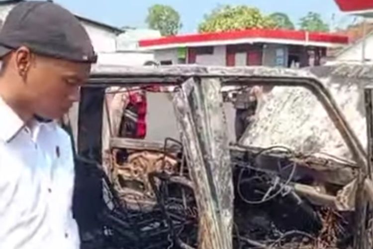 Petugas Kepolisian Polres Tasikmalaya saat memeriksa bangkai mobil Kijang yang terbakar di parkiran SPBU Jalan Mangunreja, Kabupaten Tasikmalaya, Jawa Barat, Rabu (13/11/2024).