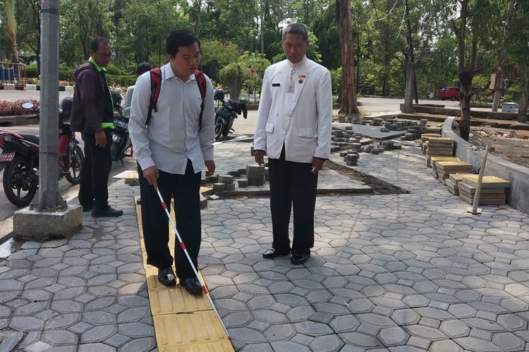 Perwakilan Tim Advokasi Difabel (TAD) Solo, Misbahul Arifin dan Sekretaris Dinas DPUR Kota Surakarta, Arif Nurhadi memperagakan guiding block yang sempat viral karena berbentuk zig-zag di Jalan Kiai Maskur tepatnya di samping utara Taman Makam Pahlawan (TMP) Jurug Solo, Jawa Tengah, Kamis (21/11/1019).