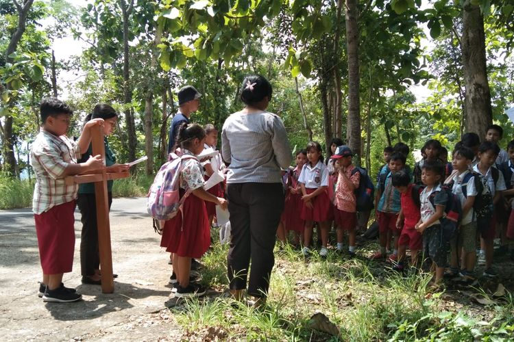 Pelajar SD Kanisius Kenalan menyimak cerita soal 14 perhentian jalan salib di Kulonprogi, DI Yogyakarta, Selasa (26/3/2024).