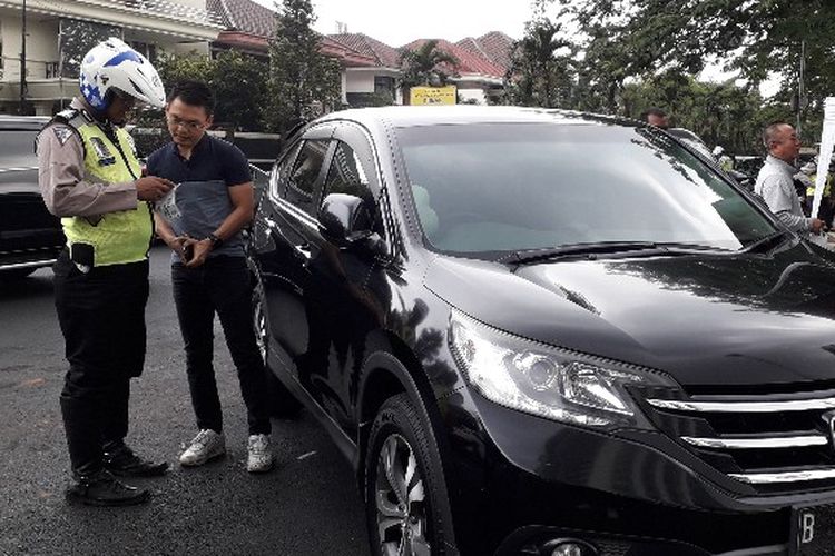 Seorang pengendara Honda CRV berpelatnomor B 1344 BJM terkena razia penesahan STNK di Jalan Puri Indah, Kembangan, Jakarta Barat pada Rabu (28/11/2018).