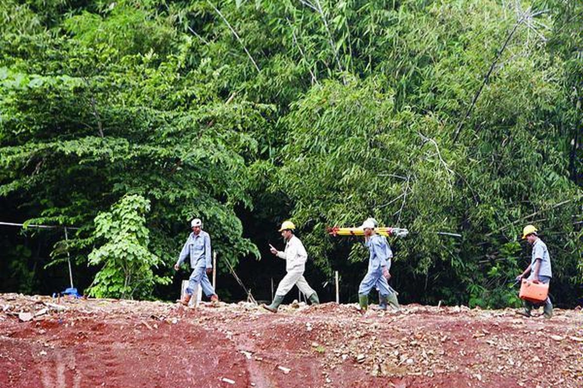 Pekerja membawa peralatan untuk mengukur lebar kanal di sepanjang proyek Banjir Kanal Timur (BKT) di Duren Sawit, Jakarta Timur, Kamis (28/2). Proyek BKT berlanjut dengan pemasangan turap setinggi 9-12 meter untuk mencegah tanah bergerak, atau longsor ke bagian tengah kanal yang telah dikeruk.  