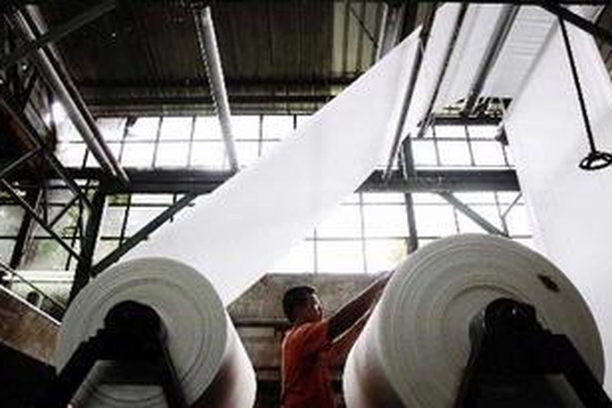 Karyawan pabrik tekstil PT Firmanjaya, Dayeuhkolot, Kaupaten Bandung, Jawa Barat, mengoperasikan mesin penggulungan kain di pabrik yang sepenuhnya bertenaga listrik, Selasa (18/1/2011).