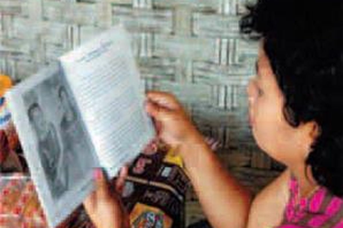 Sambil menunggu giliran pengobatan, salah seorang pasien membaca buku tentang Ponari.