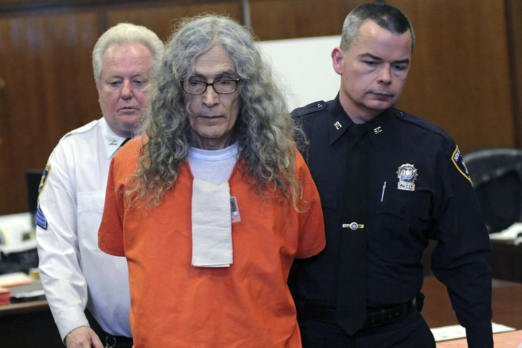 Dalam foto bertanggal 7 Januari 2013, nampak pembunuh berantai Rodney Alcala dibawa keluar dari Pengadilan New York, Amerika Serikat (AS). Alcala dijatuhi hukuman mati hingga 25 tahun penjara setelah terbukti membunuh empat perempuan dan seorang remaja 12 tahun di New York dan California.