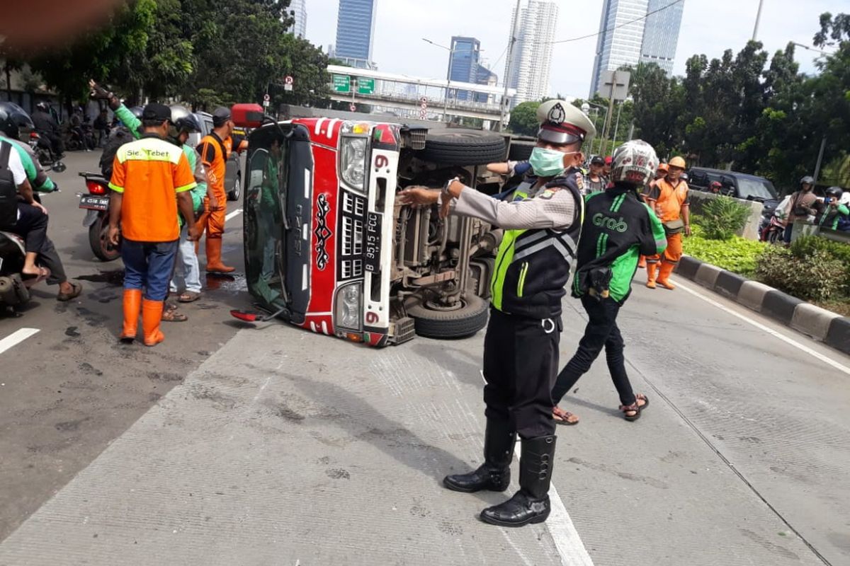 Sebuah mobil box terguling di Jalan Casablanca, Jakarta Selatan, Rabu (27/6/2018).