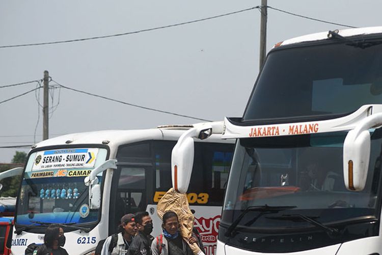 Sejumlah warga membawa barang bawaan menuju bis antar provinsi untuk mudik lebih awal di Terminal Bus Pakupatan, Serang, Banten, Kamis (23/4/2020). Meski pemerintah melarang mudik lebaran tahun 2020, sejumlah warga tetap pulang ke kampung halamannya sebelum puasa dengan alasan sudah tidak ada pekerjaan meski nantinya harus menjalani isolasi mandiri.