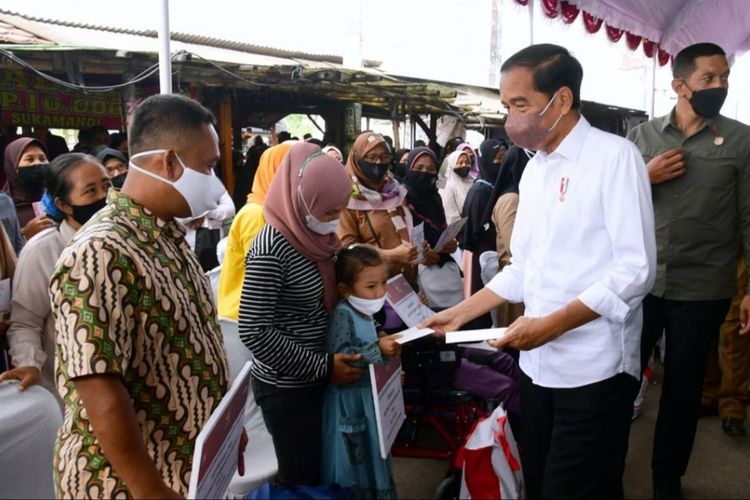 Presiden Joko Widodo saat menyerahkan bantuan sosial kepada pedagang dan masyarakat di Pasar Sukamandi, Subang, Jawa Barat, Selasa (12/7/2022).