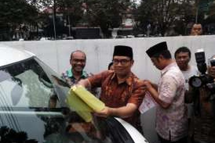 Wali Kota Bandung Ridwan Kamil saat melakukan simulasi pemasangan stiker paten pada kendaraan yang parkir sembarangan di Jalan Ahmad Yani Bandung, Jum'at (12/3/2016) kemarin. Kebijakan tersebut akan diberlakukan mulai pekan ini. 