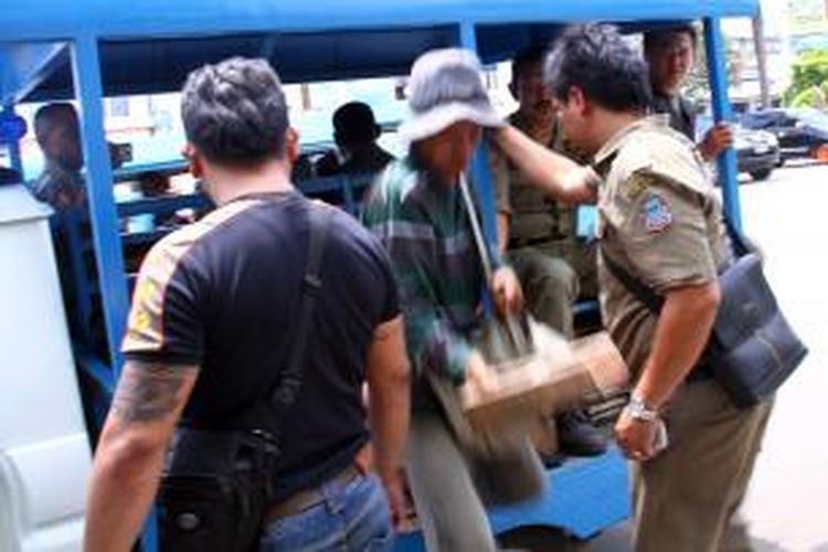 Petugas dari Satuan Polisi Pamong Praja Kota Manado melakukan razia pedagang Asongan.