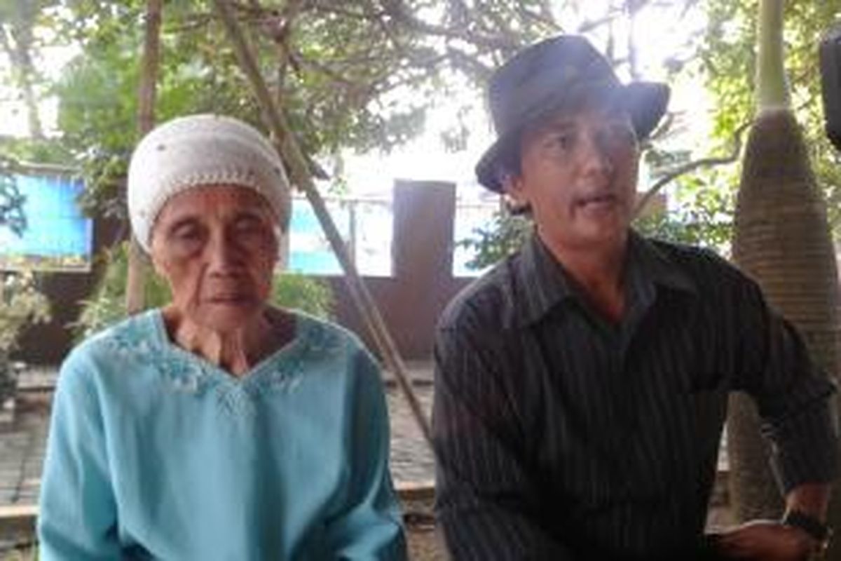 Fatimah (90) bersama cucunya, Rudi (44), tengah menunggu petugas pengadilan datang ke rumahnya untuk agenda pembuktian atas gugatan anak keempatnya, Nurhana, Jumat (26/9/2014). 