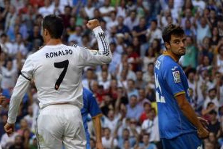 Gelandang Real Madrid, Cristiano Ronaldo (kiri), merayakan gol ke gawang Getafe pada laga Liga BBVA di Stadion Santiago Bernabeu, Madrid, Minggu atau Senin (23/9/2013) dini hari WIB.