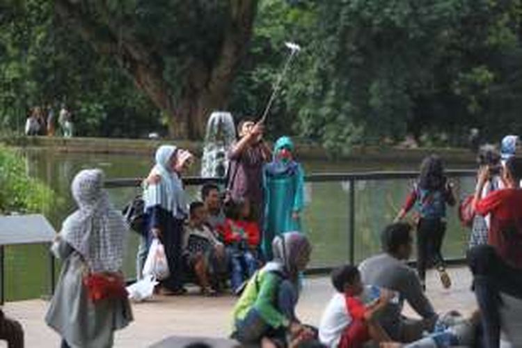 Pengunjung berfoto selfie di Kebun Raya Bogor, Bogor, Jawa Barat, Jumat (8/7/2016). Pada H 3 Lebaran dimanfaatkan wisatawan untuk mengunjungi obyek wisata.