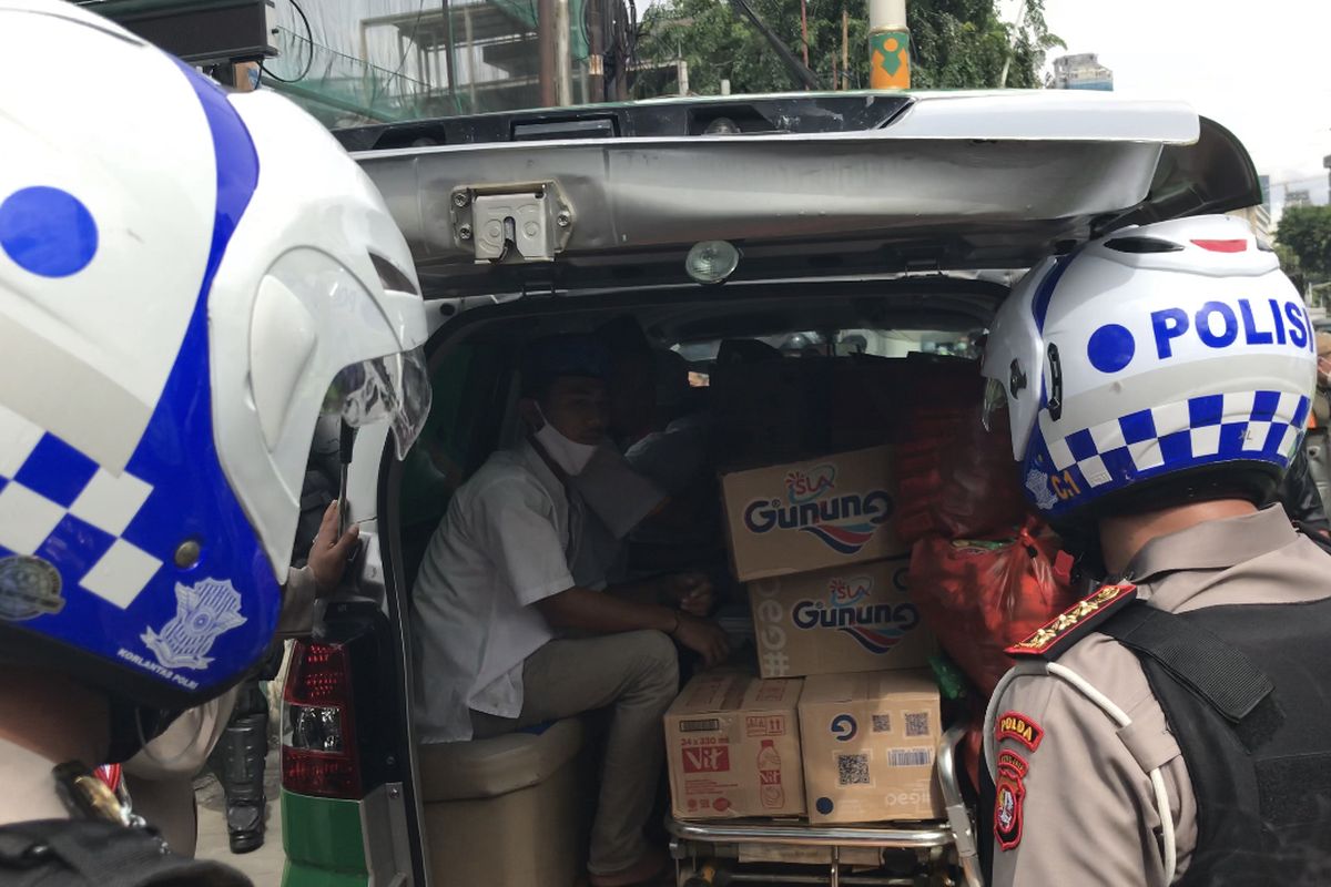 Aparat kepolisian saat memeriksa dan mengamakan satu mobil ambulans berisi logistik berupa makanan dan minuman di Jalan Jatibaru, Tanah Abang, Jakarta Pusat pada Jumat (18/12/2020) siang.
