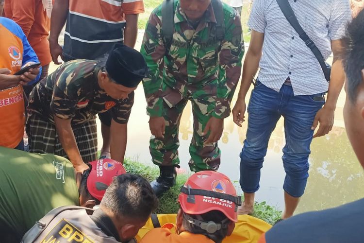 Petugas BPBD Kabupaten Nganjuk saat mengevakuasi jasad Muhammad Wildan Hidayatullah yang ditemukan tewas di di Pintu Air Saluran Sekunder Desa Bangsri, Kecamatan Kertosono, Kabupaten Nganjuk, Jumat (16/2/2024)