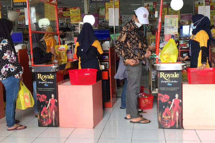 Konsumen antre di kasir untuk mendapatkan minyak goreng seharga Rp 14.000 per liter. 