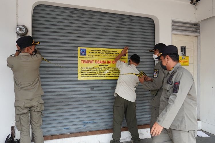 Satuan Polisi Pamong Praja (Satpol PP) Kabupaten Sleman saat menyegel salah satu tempat usaha penjualan minuman keras ilegal. Total ada 28 tempat usaha penjualan minuman beralkohol ilegal yang tersebar di sembilan kapanewon di Sleman ditutup. (Foto Dokumentasi Humas Pemkab Sleman)