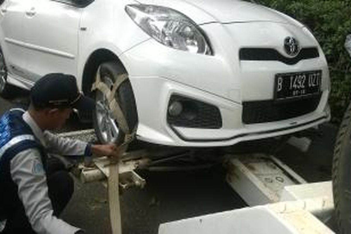 Sejumlah mobil yang parkir liar di depan kampus Interstudi ditertibkan petugas.