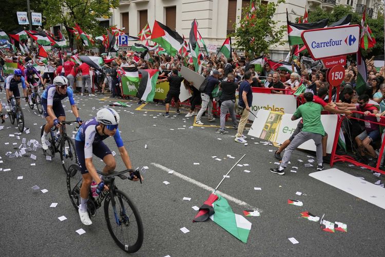 Para pebalap tim Israel Premier Tech berlomba saat orang-orang yang memegang bendera Palestina mencoba mengganggu etape kesebelas balap sepeda Vuelta Spanyol 2025, dari Bilbao ke Bilbao, Spanyol, Rabu (3/9/2025). Wakil PM Spanyol Yolanda Diaz, pada Minggu (14/9/2025), menyerukan untuk Israel diblokir dalam ajang kompetisi olahraga apa pun, seperti Rusia setelah invasi Ukraina pada 2020.