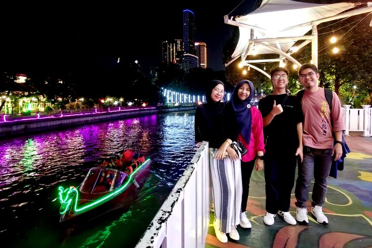 Salah satu keluarga berfoto dengan background suasana wisata perahu Kalimas menjadi salah satu destinasi wisataan untuk mengisi liburan saat berada di Surabaya, Jawa Timur.