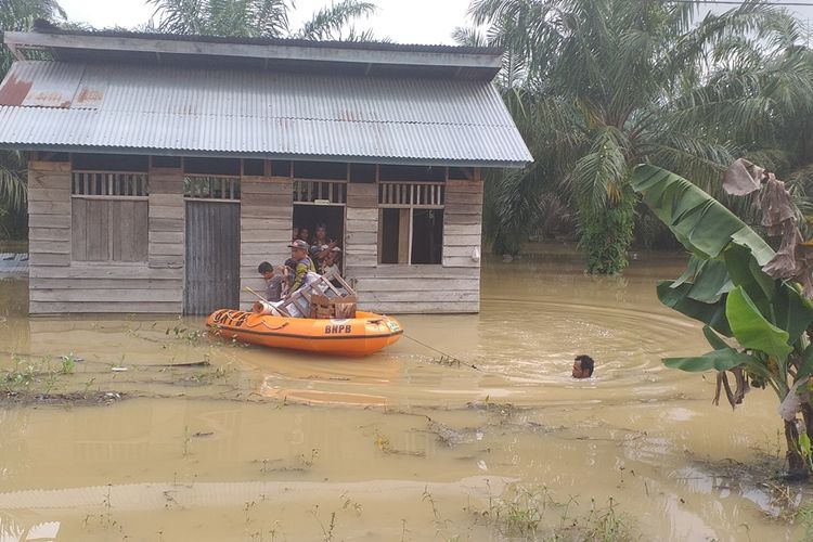 Satu keluarga korban banjir yang sudah kedinginan dievakuasi dari rumahnya di Desa Sontang, Kecamatan Bonai Darussalam, Kabupaten Rohul, Riau, Jumat (29/11/2019).