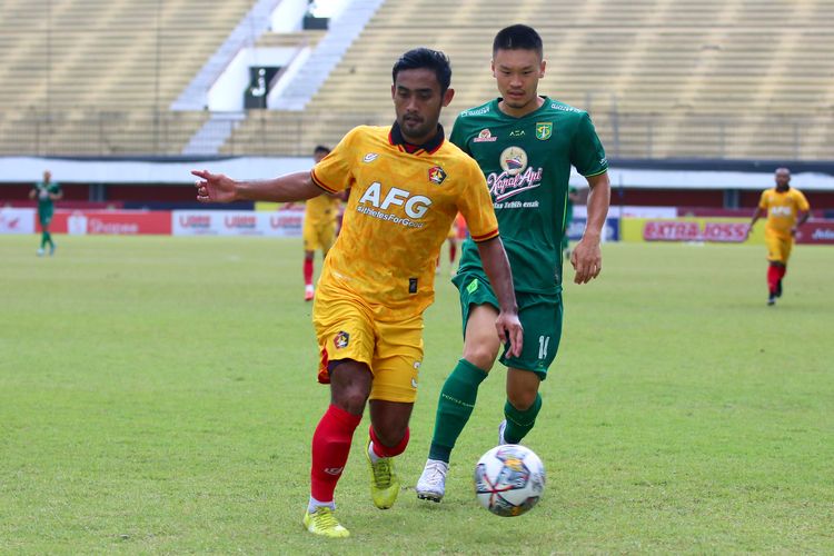 Pemain asing Persebaya Surabaya, Sho Yamamoto (belakang), berebut bola dengan pemain Persik Kediri, Agil Munawar, dalam laga pekan ke-14 Liga 1 2022-2023 yang digelar di Stadion Maguwoharjo, Sleman, Selasa (13/12/2022) sore WIB.