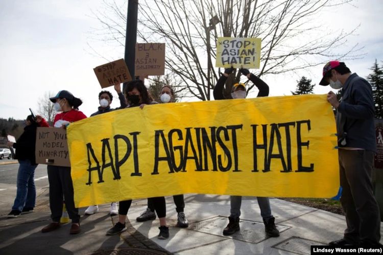 Orang-orang membentangkan spanduk AAPI Melawan Kebencian di Newcastle, Washington, AS 17 Maret 2021.