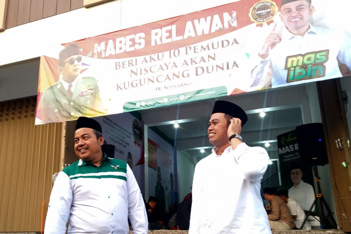 Calon Wali Kota Blitar Syauqul Muhibbin alias Ibin berpose bersama Sekretaris DPC PKB Kota Blitar Abdul Majid di depan posko pemenangan Mabes Relawan Mas Ibin di Jalan Kelud, Kota Blitar, Minggu (28/7/2024).