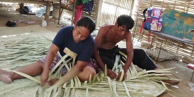 Syamsul membuat tikar bersama istrinya untuk dijual dan biaya hidup, Minggu (24/2025).