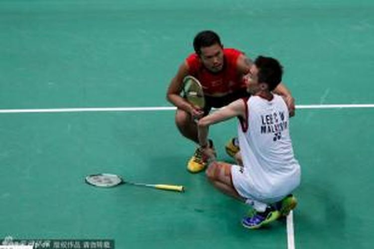 Tunggal putra China, Lin Dan (kiri), menghampiri lawannya, Lee Chong Wei yang mengalami kram kaki, pada pertandingan babak final BWF World Championships 2013, di Guangzhou, China, Minggu (11/8/2013). 