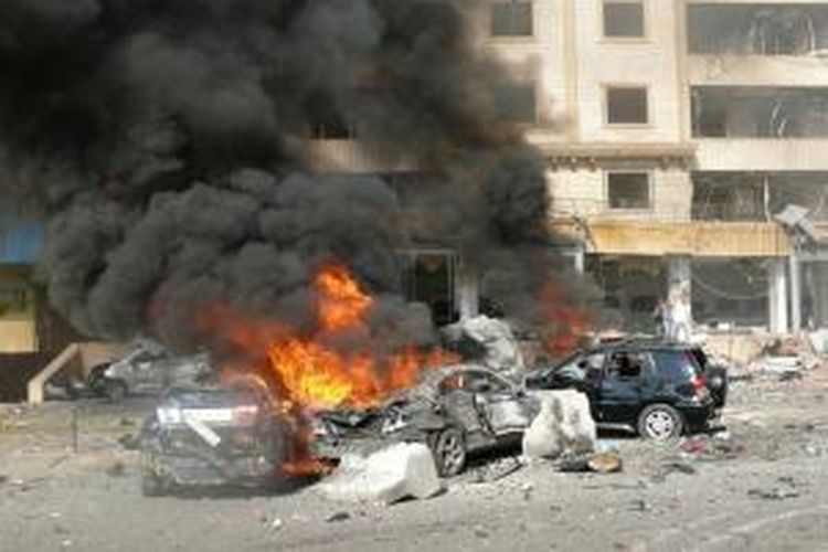 Asap mengepul dan api masih menjilat sejumlah mobil menyusul ledakan bom ganda di dekat pusat kebudayaan Iran di Beirut, Rabu (19/2/2014), menewaskan dua orang dan melukai puluhan  orang lainnya.
