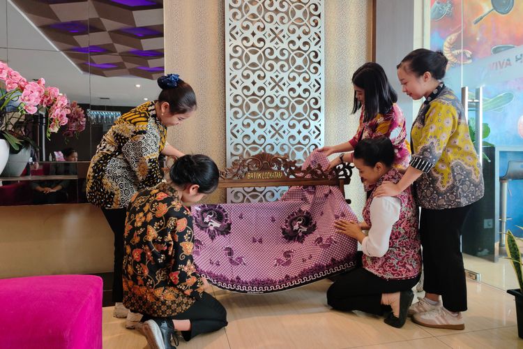 Sejumlah pegawai Viva Hotel Kediri, Jawa Timur, membeber batik yang tengah dipamerkan di hotel tersebut, Kamis (2/10/2025). Hotel bekerjasama dengan sejumlah pengrajin batik untuk mengangkat bersama warisan budaya.