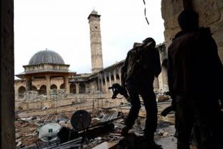Anggota pasukan pemberontak berada di kompleks Masjid Umayyah, Aleppo, utara Suriah, yang rusak akibat pertempuran, 16 April 2013. Setelah sembilan bulan pertempuran yang telah menghancurkan banyak daerah di Aleppo, pemberontak kini menguasai lebih dari setengah kota.
