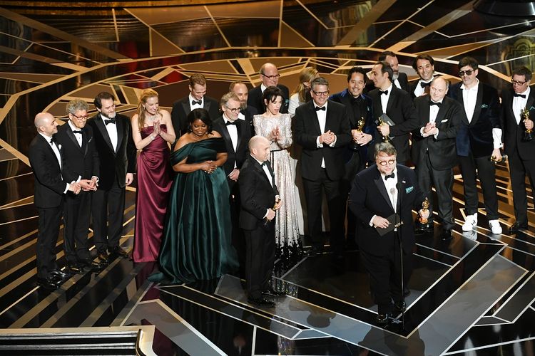 Produser J Miles Dale (kiri), sutrada Guillermo del Toro (berbicara di depan mikrofon) and dan para bintang serta kru film The Shade of Water menerima Piala Oscar untuk Best Picture pada Academy Awards ke-90 yang digelar di Dolby Theatre, Los Angeles, California, Minggu (4/3/2018). 
