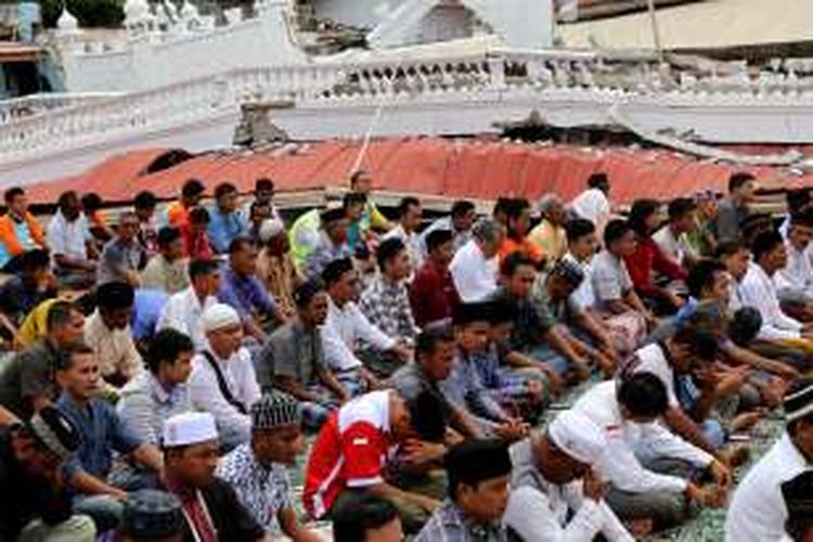 Warga melaksanakan sholat Jumat di halaman Masjid Jamik Quba, Pidie Jaya, Aceh, Jumat (9/12/2016). Warga melaksanakan Salat Jumat di halaman masjid dikarenakan robohnya masjid akibat gempa berkekuatan 6,5 SR di Pidie Jaya.