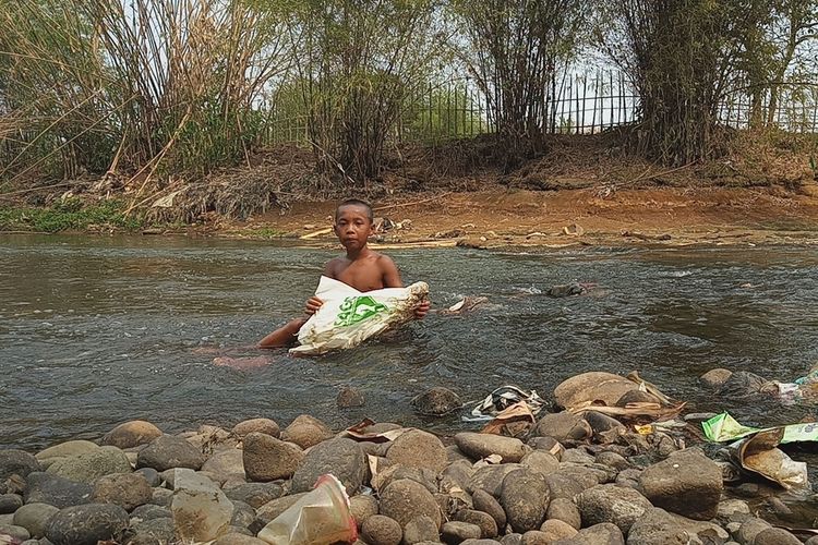 Sejumlah anak-anak berenang dan menemukan sampah plastik di bantaran Sungai Ciliwung yang tercemar gunung sampah yang ada di Kampung Kedunghalang Lebak, Desa Cilebut Timur, Kecamatan Sukaraja, Bogor, Jawa Barat, Rabu (25/9/2019).