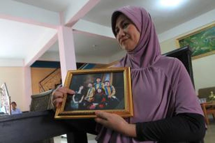Rohana, ibu Khairunisa Haidar, pramugari AirAsia QZ8501 menunjukkan foto Nisa dan keluarganya di Palembang, Sumatera Selatan, Minggu (28/12/2014).