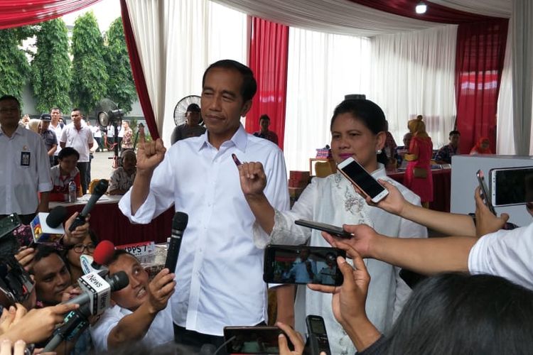 Jokowi didampingi istri, Iriana Jokowi, mencoblos di Tempat Pemungutan Suara (TPS) 008 yang terletak di pelataran gedung Lembaga Administrasi Negara, Kelurahan Gambir, Kecamatan Gambir, Jakarta Pusat.
