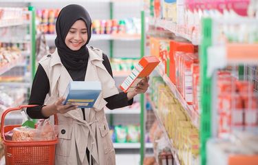 Ilustrasi - Seorang wanita membeli produk halal di supermarket.