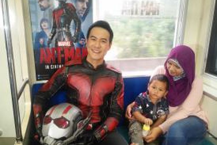 Daniel Mananta yang berkostum Ant-Man berfoto bersama penumpang KRL (Kereta rel listril) rute Stasiun Kota-Manggarai, Sabtu (11/7/2015) siang.