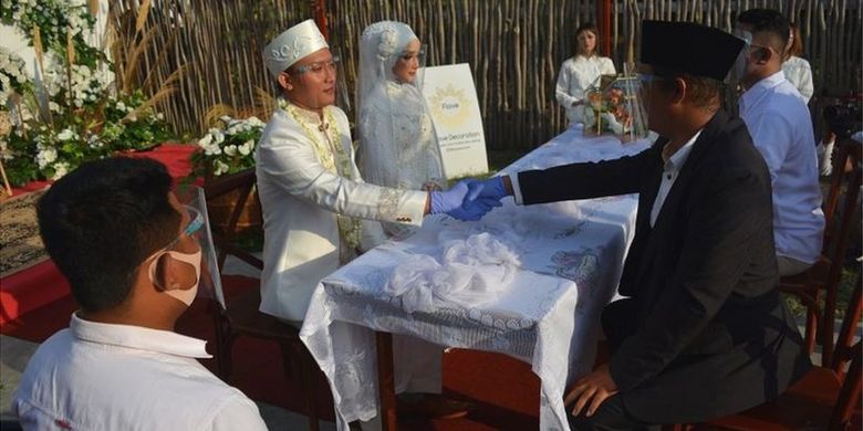 Pengantin melaksanakan ijab kabul dalam simulasi resepsi pernikahan di era normal baru dengan protokol kesehatan di Kabupaten Jombang, Jawa Timur, 14 Juli lalu.