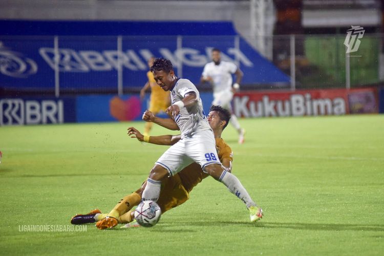Pemain Bhayangkara FC menghalau pemain Arema FC Kushedya Hari Yudo saat menggiring bola pada pertandingan pekan 18 Liga 1 2021-2022 yang berakhir dengan skor 0-1 di Stadion Kompyang Sujana Denpasar, Bali, Minggu (9/1/2022) malam.