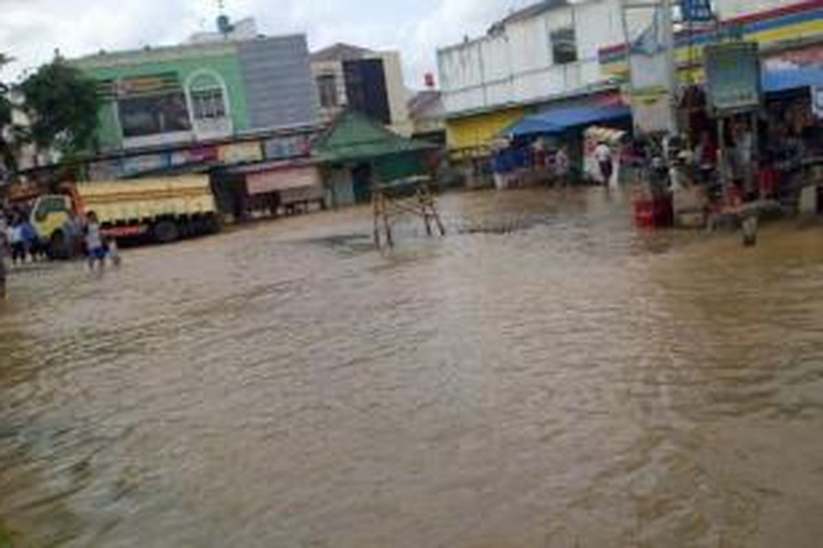 Jalan Raya Bintara Bekasi tergenang air hingga sedalam 40 cm, Rabu (29/1/2014). Sejumlah pengendara sepeda motor berupaya melewati jalan tersebut dan sebagian di antaranya mogok.