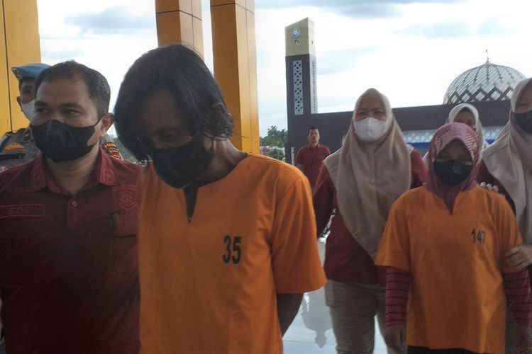 Pelaku yang menyiksa anak tirinya, Zulkifli dan istrinya, Meli Oktavia digelandang petugas ke tahanan usai dihadirkan dalam konferensi pers di Mapolda Riau di Pekanbaru, Kamis (27/10/2022).