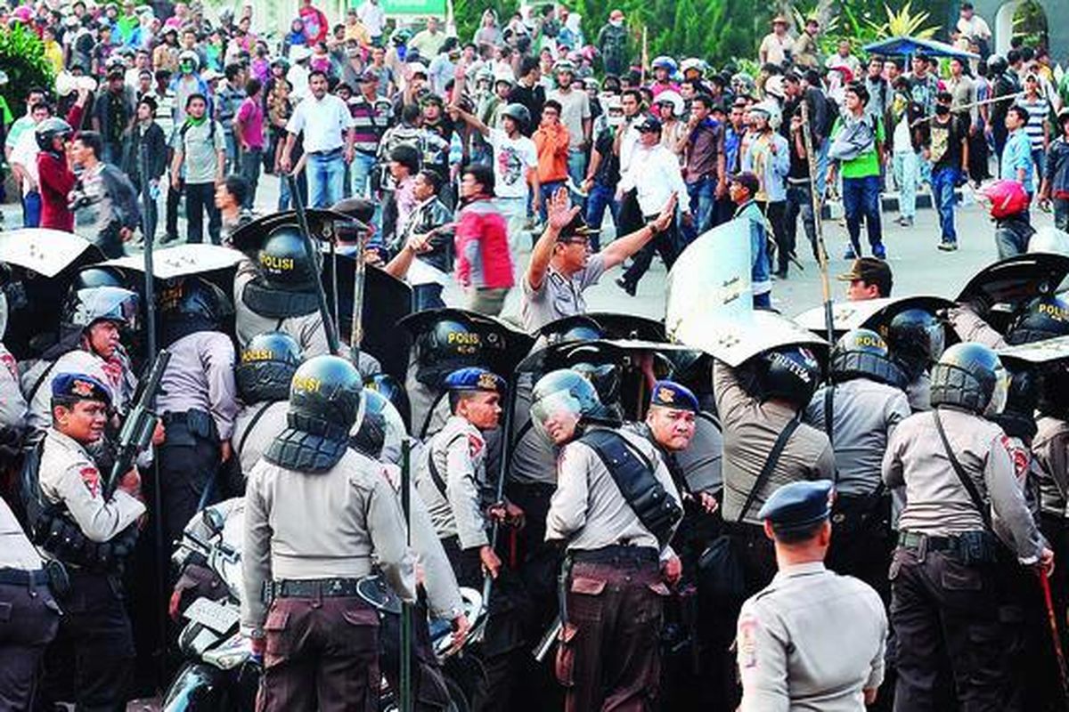Polisi penjaga Bandara Internasional Polonia, Medan, mendesak pengunjuk rasa untuk mundur, Senin (26/3). Operasional Bandara Internasional Polonia sempat terhambat oleh kepungan belasan ribu pengunjuk rasa yang menuntut pembatalan rencana kenaikan harga bahan bakar minyak.
